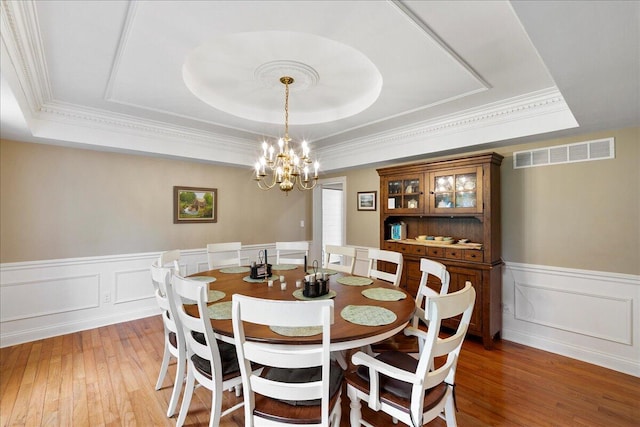 1183 The Ridings, Winchester, KY 40391 - dining area featuring a tray ceiling, a chandelier, light wood-style flooring, a wainscoted wall, and ornamental molding