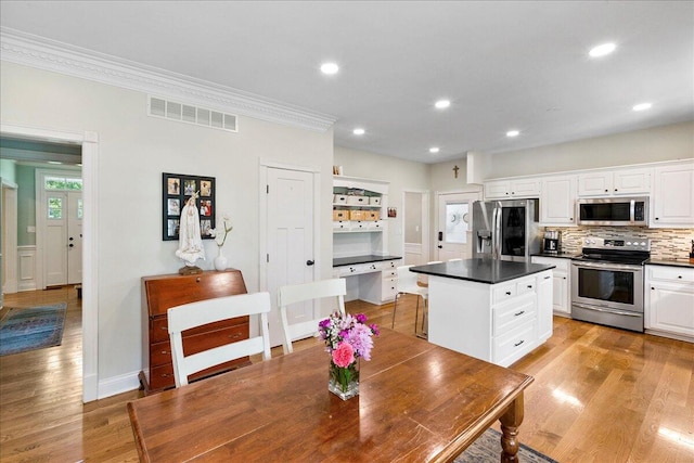 1183 The Ridings, Winchester, KY 40391 - kitchen featuring stainless steel appliances, dark countertops, crown molding, white cabinets, and light wood finished floors