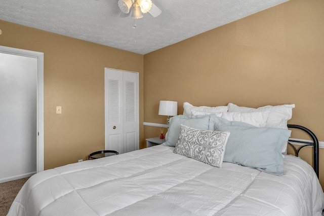 carpeted bedroom featuring a closet, baseboards, ceiling fan, and a textured ceiling