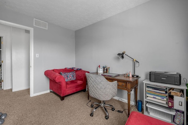 carpeted home office with baseboards and a textured ceiling