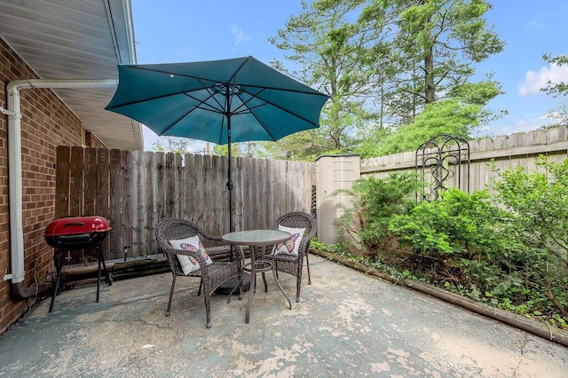 view of patio with a fenced backyard, outdoor dining area, and grilling area