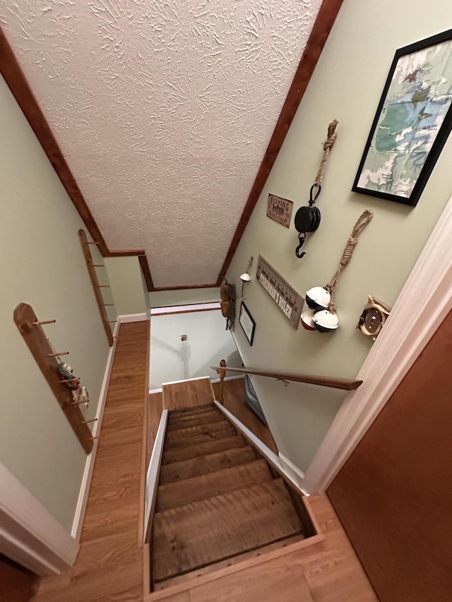 100 Buck Dr, Wellington, KY 40387 - staircase featuring a textured ceiling, wood finished floors, and baseboards