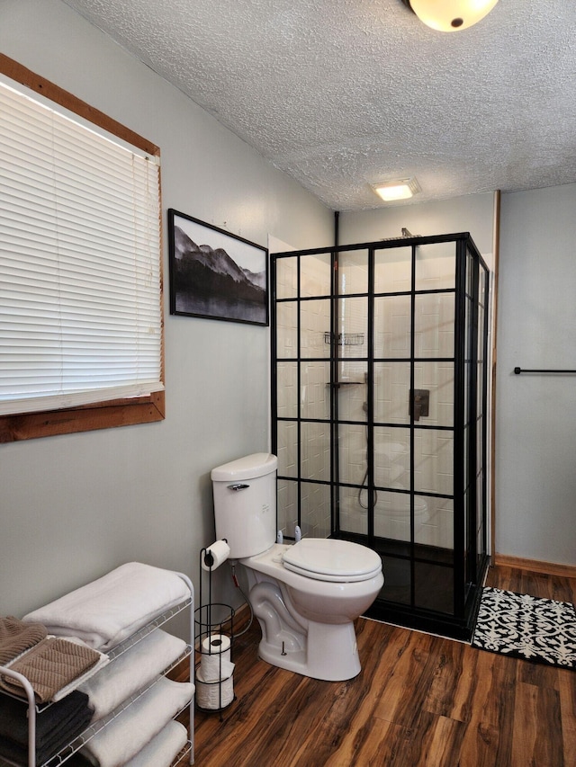 42 Alley Rd, Wellington, KY 40387 - full bath featuring wood finished floors, a shower stall, toilet, a textured ceiling, and baseboards