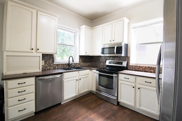 50 Sterling Ave, Fort Thomas, KY 41075 - kitchen with appliances with stainless steel finishes, a sink, dark countertops, decorative backsplash, and ornamental molding