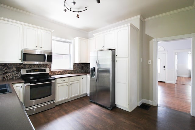 50 Sterling Ave, Fort Thomas, KY 41075 - kitchen featuring appliances with stainless steel finishes, decorative backsplash, dark countertops, dark wood finished floors, and white cabinetry