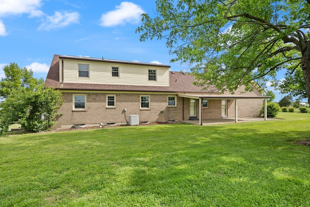 back of house featuring a patio area, a lawn, brick siding, and cooling unit