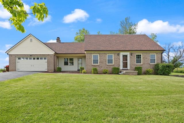 view of front of house featuring brick siding, driveway, a front lawn, a garage, and a chimney