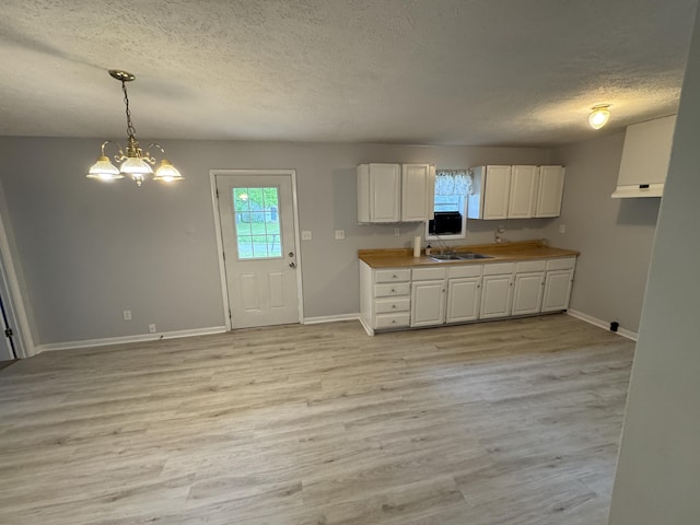 357 Powell Rd, Clay City, KY 40312 - kitchen featuring a textured ceiling, white cabinets, baseboards, light wood-style flooring, and a chandelier