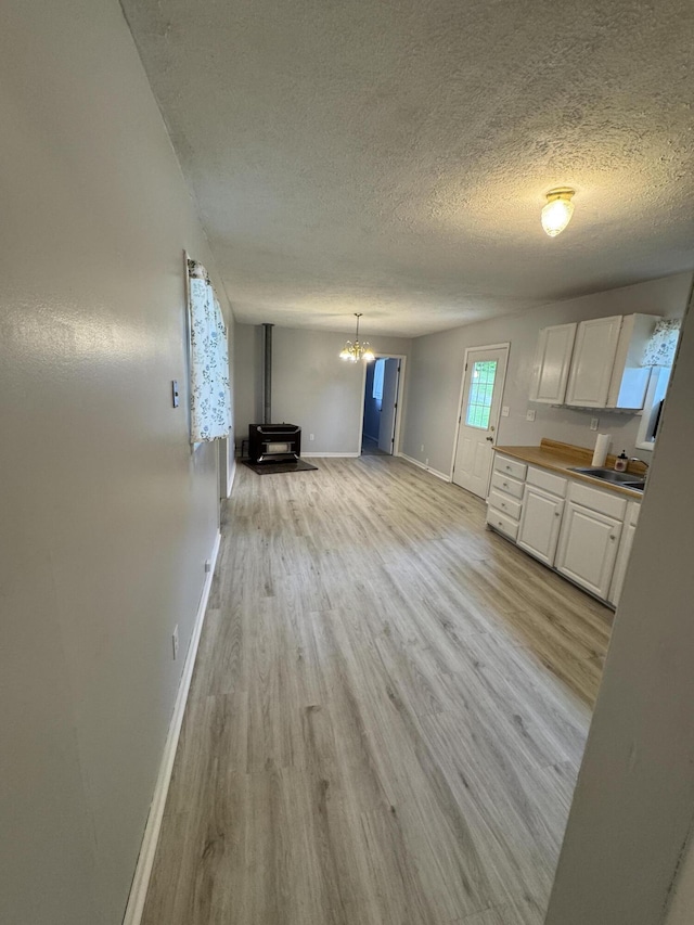 357 Powell Rd, Clay City, KY 40312 - kitchen featuring white cabinets, light wood finished floors, a textured ceiling, baseboards, and a chandelier