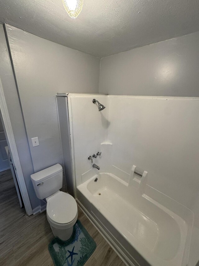 357 Powell Rd, Clay City, KY 40312 - bathroom featuring wood finished floors, a textured ceiling, toilet, and shower / bath combination