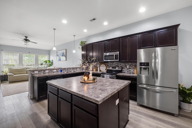 157 Cross Park Dr, Georgetown, KY 40324 - kitchen with appliances with stainless steel finishes, open floor plan, a kitchen island, dark brown cabinets, and light wood finished floors