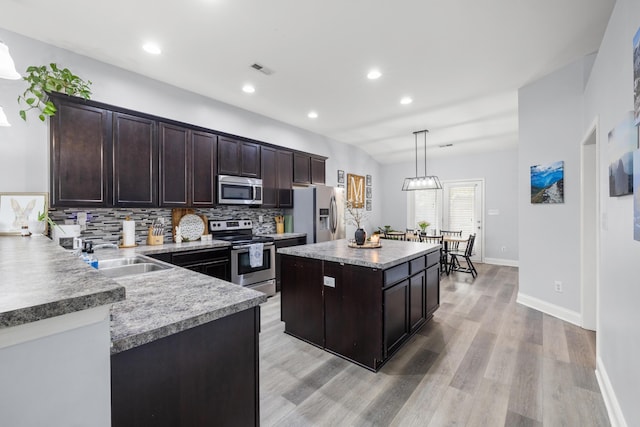 157 Cross Park Dr, Georgetown, KY 40324 - kitchen featuring stainless steel appliances, a sink, dark brown cabinets, light wood-style floors, and decorative backsplash
