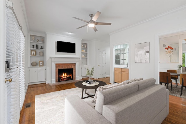 303 Patchen Dr, Lexington, KY 40517 - living area with a fireplace with flush hearth, wood finished floors, ceiling fan, built in features, and crown molding