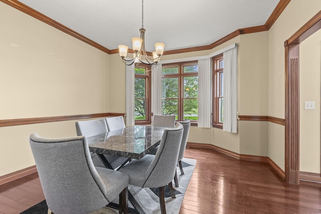 dining area with wood-type flooring, a chandelier, baseboards, and crown molding