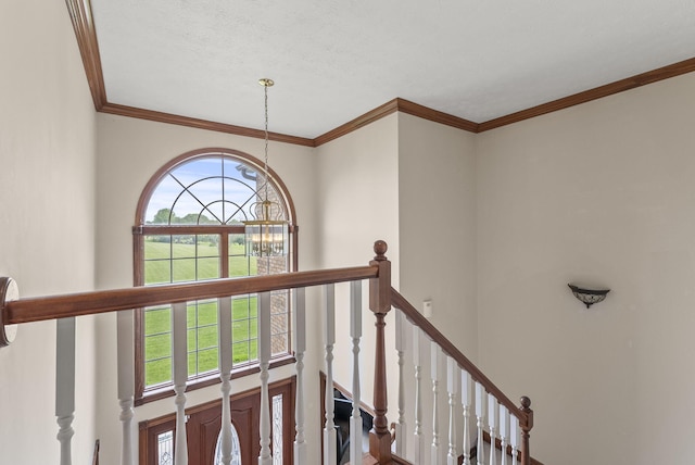 stairs featuring crown molding and a chandelier