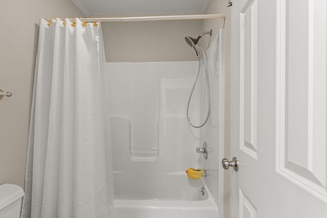 bathroom with shower / tub combo and toilet