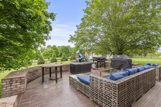 view of patio / terrace with a playground, outdoor lounge area, a grill, fence, and outdoor dining space