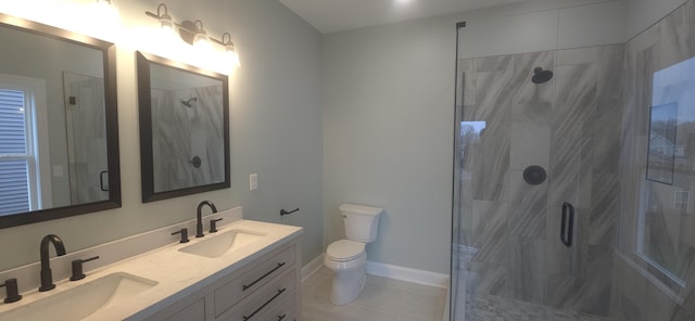 full bath featuring a shower stall, toilet, double vanity, baseboards, and tile patterned floors