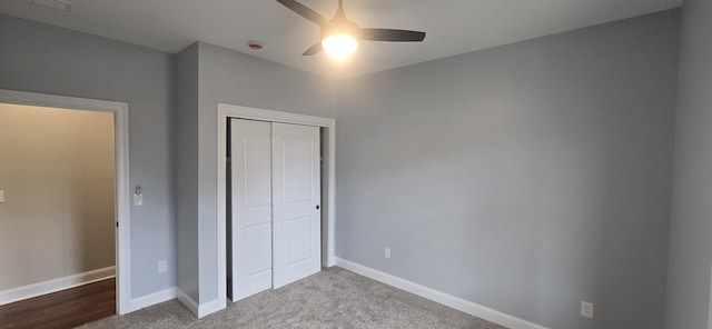 unfurnished bedroom featuring a closet, baseboards, carpet floors, and a ceiling fan