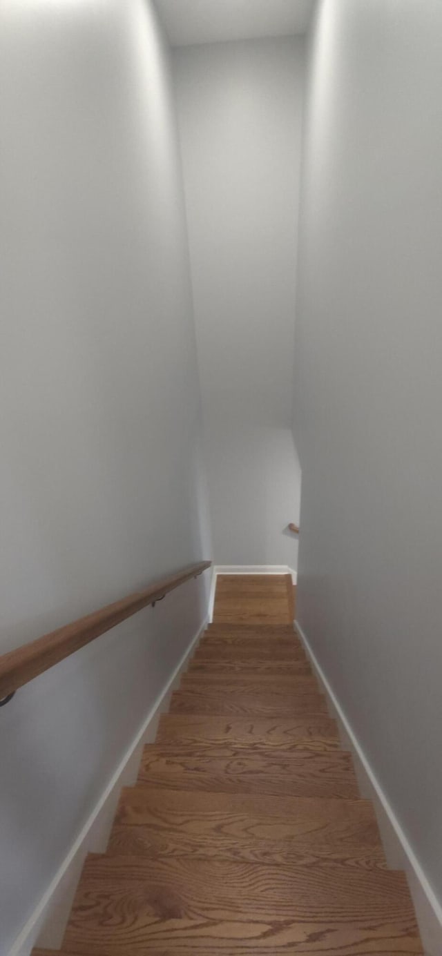 stairway featuring wood finished floors and baseboards
