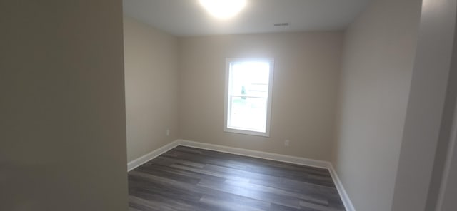 spare room with dark wood-style floors and baseboards
