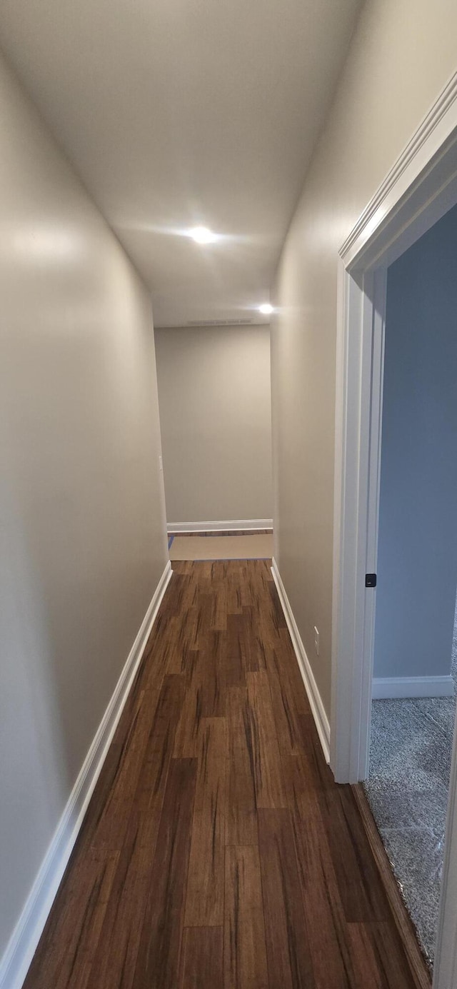 hall featuring dark wood finished floors and baseboards