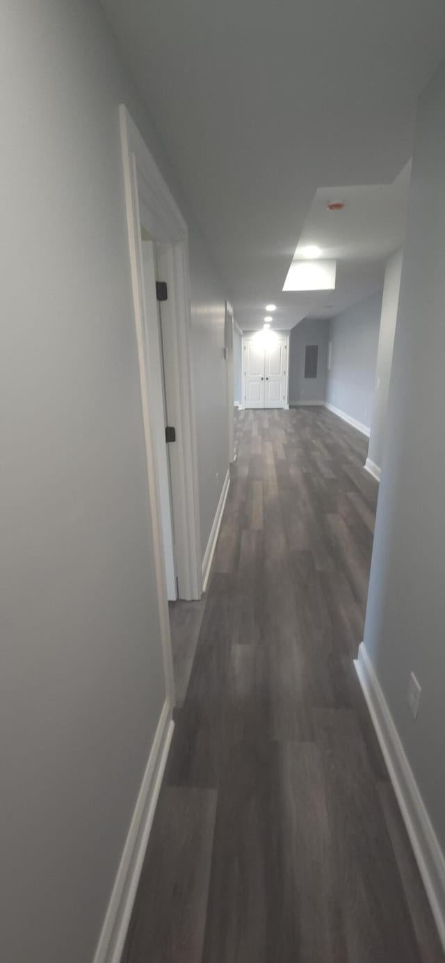hallway with baseboards and dark wood finished floors