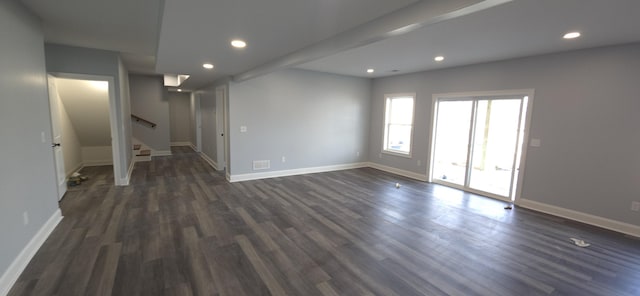 below grade area featuring dark wood finished floors, baseboards, stairs, and recessed lighting