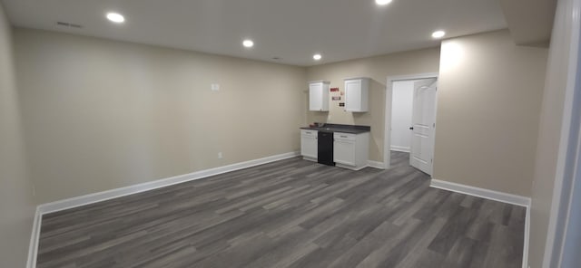 empty room featuring baseboards, dark wood-style flooring, and recessed lighting