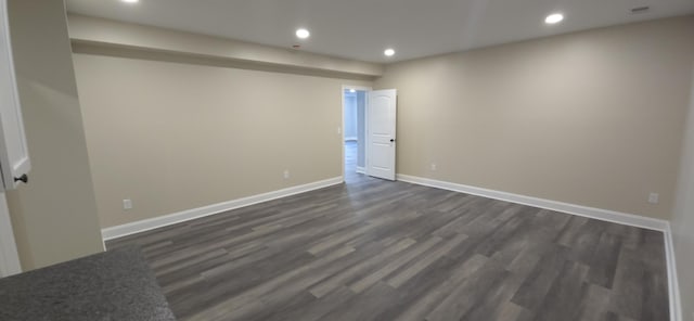 empty room featuring recessed lighting, dark wood-type flooring, and baseboards