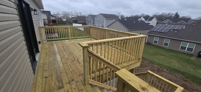 wooden deck with a residential view and a lawn