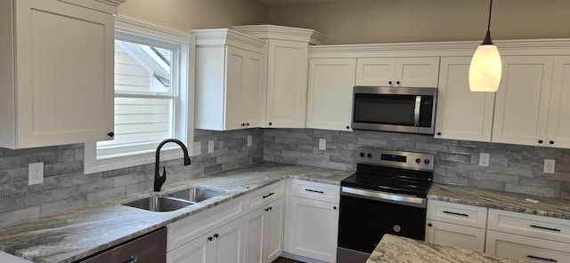 kitchen featuring appliances with stainless steel finishes, a sink, white cabinets, and backsplash