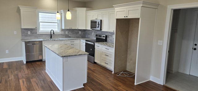 kitchen featuring appliances with stainless steel finishes, a sink, tasteful backsplash, and a kitchen island
