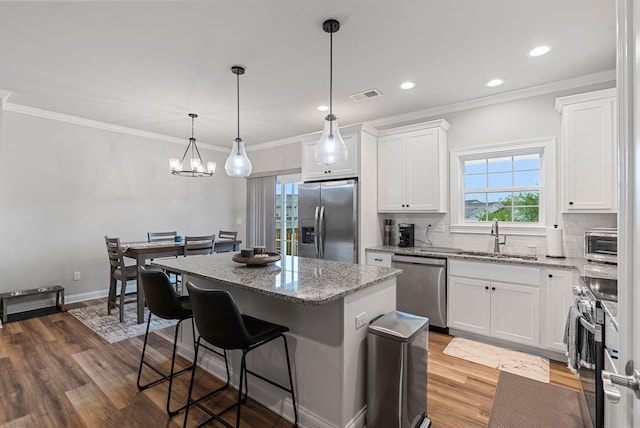 3008 Locust Blossom Cv, Lexington, KY 40511 - kitchen with stainless steel appliances, a sink, a center island, a breakfast bar, and white cabinets