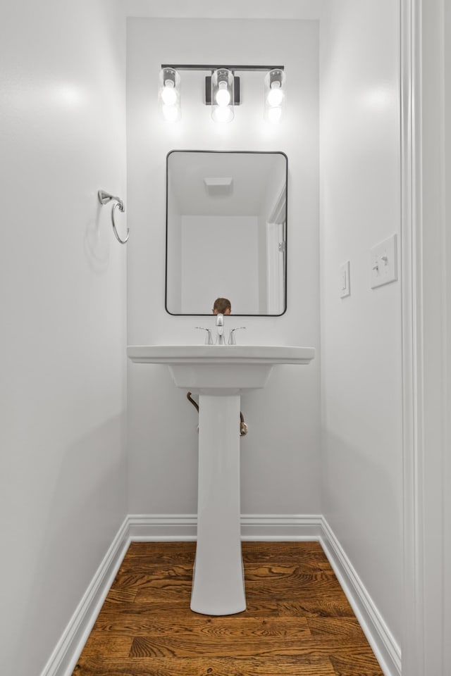 bathroom with wood finished floors and baseboards