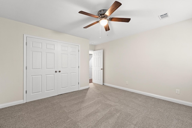 unfurnished bedroom featuring carpet flooring, a closet, baseboards, and a ceiling fan