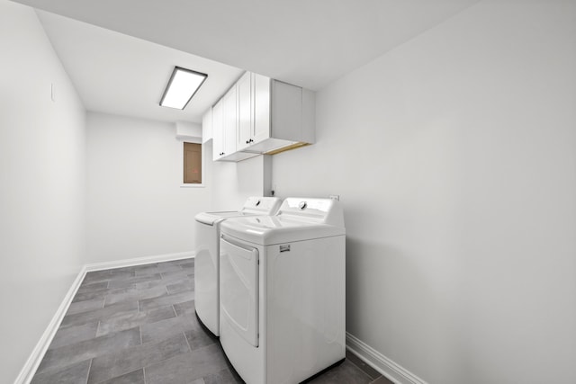 laundry area with washing machine and dryer, cabinet space, and baseboards