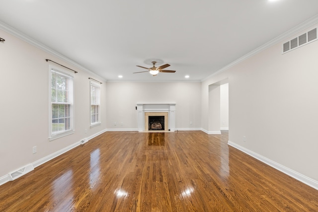 unfurnished living room featuring wood finished floors, ornamental molding, ceiling fan, a fireplace with flush hearth, and baseboards