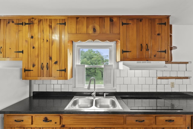 834 Boyd Ave, Danville, KY 40422 - kitchen featuring a sink, under cabinet range hood, brown cabinetry, dark countertops, and decorative backsplash