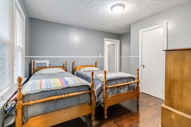 bedroom with a textured ceiling and wood finished floors