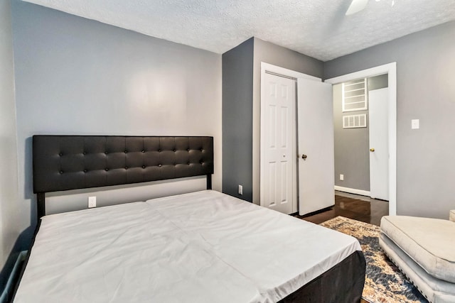 bedroom featuring a textured ceiling, a closet, baseboards, and a ceiling fan