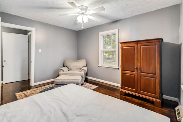 bedroom with a textured ceiling, dark wood-style flooring, baseboards, and ceiling fan