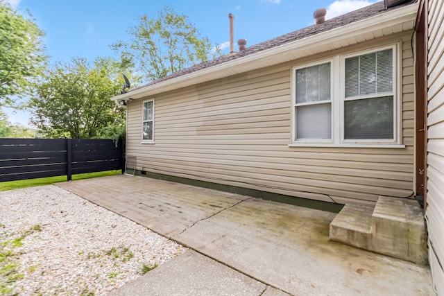 view of property exterior with fence and a patio area