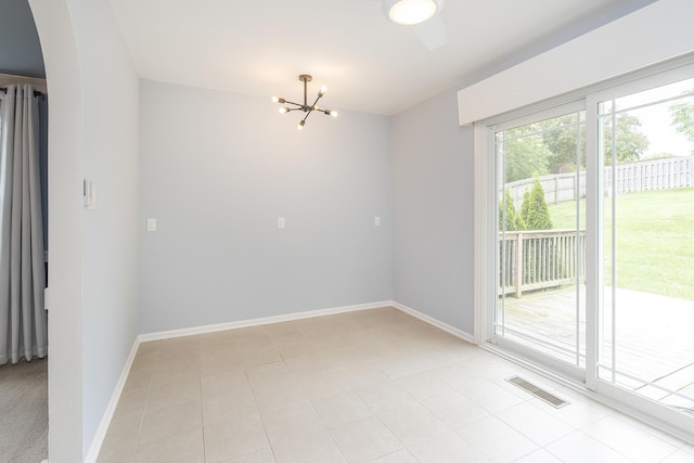 spare room with a chandelier, arched walkways, baseboards, and light tile patterned flooring