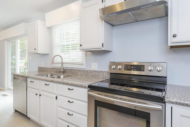 kitchen with appliances with stainless steel finishes, under cabinet range hood, a sink, and white cabinetry