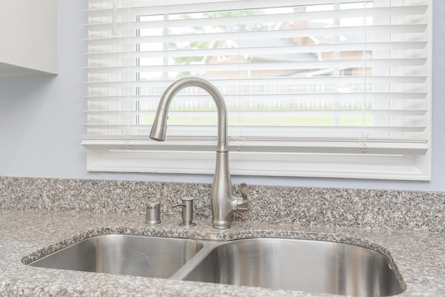 kitchen view of a sink and light stone countertops