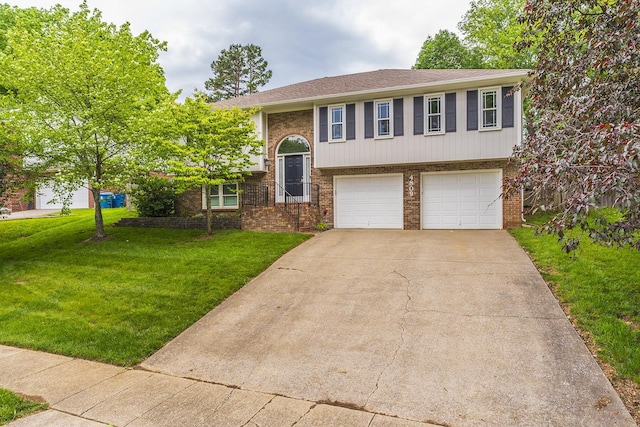 raised ranch featuring brick siding, a garage, a front lawn, and driveway