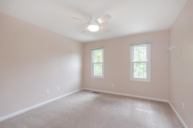 unfurnished room with ceiling fan, baseboards, and light colored carpet