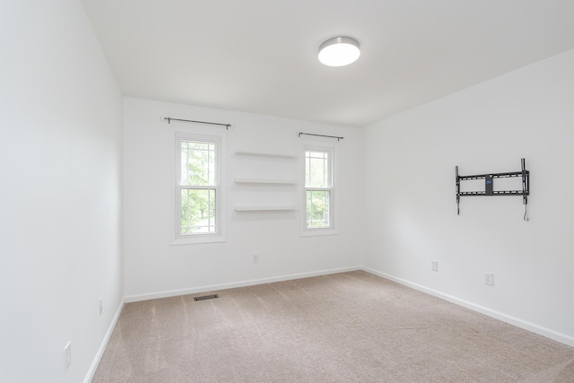 carpeted spare room featuring baseboards