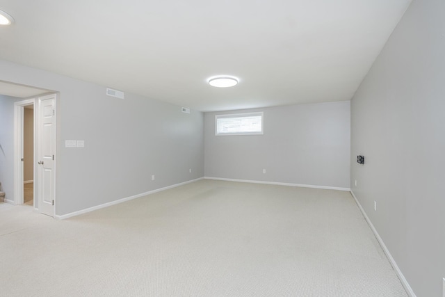 below grade area featuring light carpet and baseboards